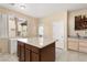 Open kitchen with a center island, tile floors, wood cabinets, and bright window at 5934 Reflection Point Ct, Las Vegas, NV 89110