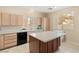 Bright kitchen with a center island, tile floors, wood cabinets, and modern appliances at 5934 Reflection Point Ct, Las Vegas, NV 89110