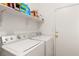 Functional laundry room with modern washer and dryer, storage shelves, and a white door at 5934 Reflection Point Ct, Las Vegas, NV 89110