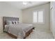 Well-lit bedroom with neutral tones features a ceiling fan and shuttered windows at 6059 Saddle Horse Ave, Las Vegas, NV 89122