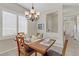 A dining room area is brightened with white plantation shutters and features a wood table and view of front entryway at 6059 Saddle Horse Ave, Las Vegas, NV 89122