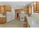 Bright kitchen with tile flooring, neutral paint, white appliances, and wood cabinets at 6059 Saddle Horse Ave, Las Vegas, NV 89122