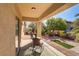 Relaxing outdoor patio area with shaded seating and views of the manicured backyard at 6059 Saddle Horse Ave, Las Vegas, NV 89122