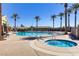 Sparkling community pool and hot tub surrounded by palm trees and comfortable lounge chairs at 6059 Saddle Horse Ave, Las Vegas, NV 89122