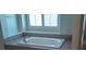 Bright bathroom showcasing a soaking tub below a window, set in a tiled surround at 6120 Matisse Ave, Las Vegas, NV 89131