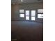Large living room with carpet, lots of windows and a double glass door at 6120 Matisse Ave, Las Vegas, NV 89131