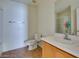 Bright bathroom with a toilet, sink, mirror, and tan tile flooring at 6134 Pine Villa Ave # 103, Las Vegas, NV 89108