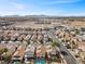 An aerial view showcasing a residential neighborhood near industrial infrastructure against a mountain backdrop at 6328 Brianna Peak Ct, Las Vegas, NV 89142