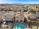 Aerial view shows a house with a pool in a residential neighborhood with mountain views at 6328 Brianna Peak Ct, Las Vegas, NV 89142