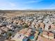 An aerial view of a residential area featuring houses, streets, and community amenities in the distance at 6328 Brianna Peak Ct, Las Vegas, NV 89142