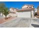 Two-story home boasts a two-car garage and a well-maintained driveway, surrounded by desert landscaping at 6328 Brianna Peak Ct, Las Vegas, NV 89142