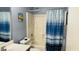 Full bathroom features shower-tub combo with a striped shower curtain and blue walls at 6445 Glory Rise Ct, Las Vegas, NV 89142