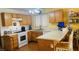 Bright kitchen featuring white appliances, light wood cabinets and breakfast bar at 6445 Glory Rise Ct, Las Vegas, NV 89142