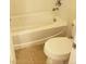 Bright bathroom featuring a standard bathtub and a white toilet with tan tile flooring at 6541 Chinatown St, Las Vegas, NV 89166