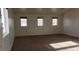 Expansive bedroom with a trio of windows allowing natural light, complemented by neutral carpeting at 6541 Chinatown St, Las Vegas, NV 89166