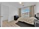 Comfortable bedroom with laminate wood floor, large window with blinds, and black wooden drawers at 6817 Frances Celia Ave, Las Vegas, NV 89122