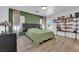 Comfortable main bedroom with laminate wood floors, olive accent wall, large bed, and open shelving at 6817 Frances Celia Ave, Las Vegas, NV 89122