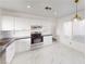 Modern kitchen with stainless steel appliances, white cabinets, marble floors, and ample counter space at 6944 Emerald Springs Ln, Las Vegas, NV 89113