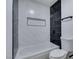 Modern bathroom with a white tub and a black tiled shower featuring a built in niche at 7437 Lattimore Dr, Las Vegas, NV 89128