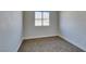 A simple bedroom with neutral carpet, white walls, and natural light from a double pane window at 7437 Lattimore Dr, Las Vegas, NV 89128