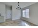 Dining area featuring wood-look floors, modern chandelier, and a large window at 7437 Lattimore Dr, Las Vegas, NV 89128