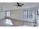 This living room is empty with wood floors, a chandelier, and large windows at 7437 Lattimore Dr, Las Vegas, NV 89128
