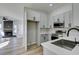 Open-concept kitchen and living space featuring modern design and wood-look floors at 7437 Lattimore Dr, Las Vegas, NV 89128