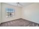Neutral bedroom featuring soft carpeting, a ceiling fan, and natural light from a window at 8425 Sewards Bluff Ave, Las Vegas, NV 89129