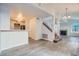 Open-concept living area with gray tile flooring, staircase and views of the kitchen at 8425 Sewards Bluff Ave, Las Vegas, NV 89129