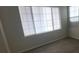 Bedroom featuring a bright window with blinds, and modern flooring, creating a cozy and well-lit space at 8695 Canfield Canyon Ave, Las Vegas, NV 89178