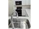 Bright kitchen with stainless steel sink, black gas range, white cabinets and countertops at 8695 Canfield Canyon Ave, Las Vegas, NV 89178
