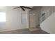 Spacious living room featuring high ceilings, a ceiling fan, natural light, and staircase access at 8695 Canfield Canyon Ave, Las Vegas, NV 89178