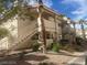 Two story condo with steps leading to the second floor units and desert landscaping at 924 Falconhead Ln # 102, Las Vegas, NV 89128