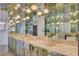 An opulent mirrored bathroom with double sinks and brass fixtures and lighting at 945 Vegas Valley Dr, Las Vegas, NV 89109