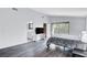 A well-lit bedroom with wood floors, a TV on a white console, access to the bathroom, and a sliding glass door at 945 Vegas Valley Dr, Las Vegas, NV 89109