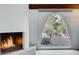 Close-up of the stone fireplace and arched window offering a view of the exterior landscape at 945 Vegas Valley Dr, Las Vegas, NV 89109