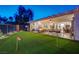 Beautiful backyard with lush artificial grass, putting green, and a cozy outdoor seating area with a fire pit at 10621 Tinta Ln, Las Vegas, NV 89144