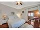 Cozy bedroom showcases hardwood floors, a ceiling fan, and access to another room at 10621 Tinta Ln, Las Vegas, NV 89144