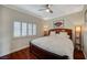 Inviting bedroom features hardwood floors, a ceiling fan, and large window at 10621 Tinta Ln, Las Vegas, NV 89144