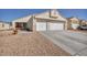 Charming single-story home featuring a two-car garage and desert landscaping at 1104 Christopher View Ave, North Las Vegas, NV 89032