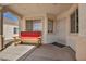Cozy covered front porch seating area with a rustic wooden bench at 1104 Christopher View Ave, North Las Vegas, NV 89032