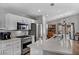 Bright kitchen features an island with white cabinets, stainless steel appliances, and wood flooring at 1104 Christopher View Ave, North Las Vegas, NV 89032