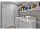 Clean laundry room features a washer and dryer, plus storage shelves at 1104 Christopher View Ave, North Las Vegas, NV 89032