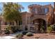 Inviting two-story home with stone detailing, arched entry, and lush landscaping at 11268 Corsica Mist Ave, Las Vegas, NV 89135