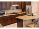 Modern kitchen showcasing granite countertops, dark wood cabinetry, and stainless steel refrigerator at 11268 Corsica Mist Ave, Las Vegas, NV 89135