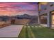 Beautiful backyard with lush artificial turf, a large patio and mountain views at sunset at 12453 Foxtail Run Ave, Las Vegas, NV 89138