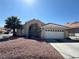 Charming single-story home featuring stucco siding, a two-car garage, and mature palm trees in the front yard at 1301 Misty View Ct, North Las Vegas, NV 89031