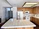 Spacious kitchen featuring light wood cabinets, tile countertops, an island, and modern white appliances at 1301 Misty View Ct, North Las Vegas, NV 89031