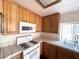 Classic kitchen featuring oak cabinets, tile countertops, and modern white appliances for a functional cooking space at 1301 Misty View Ct, North Las Vegas, NV 89031
