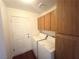 Laundry room featuring a washer, dryer, storage cabinets and a white door leading to the exterior at 1301 Misty View Ct, North Las Vegas, NV 89031